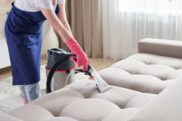 A Tyra's cleaner deep-cleaning an upholstered sofa